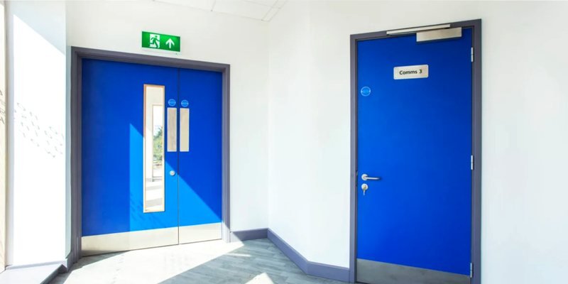 Fire-rated doors with intumescent seals in a healthcare corridor